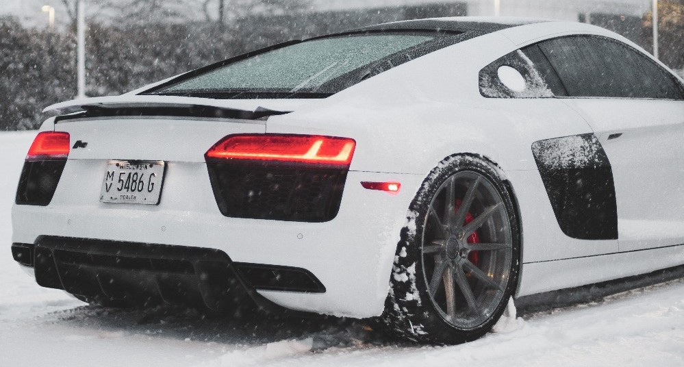 rear view of white audi driving in snow