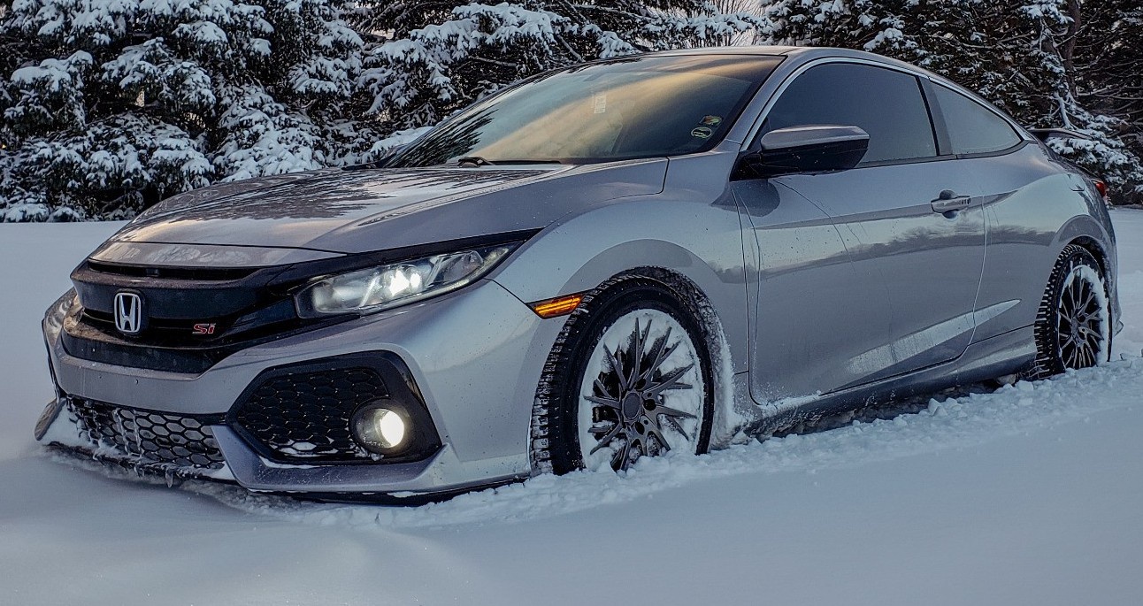 profile view of silver honda driving through snow