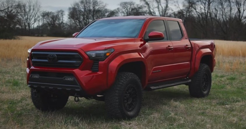 front view of red toyota tacoma in field