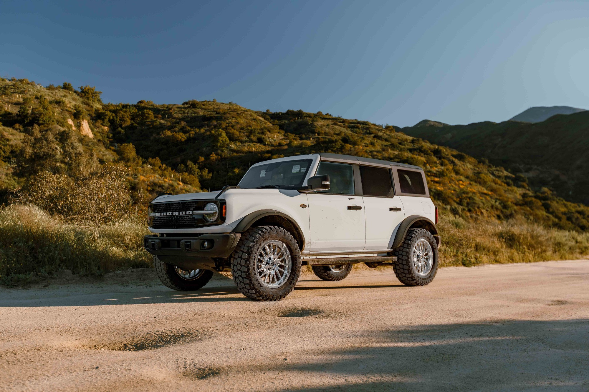 White ford bronco driving on side of road