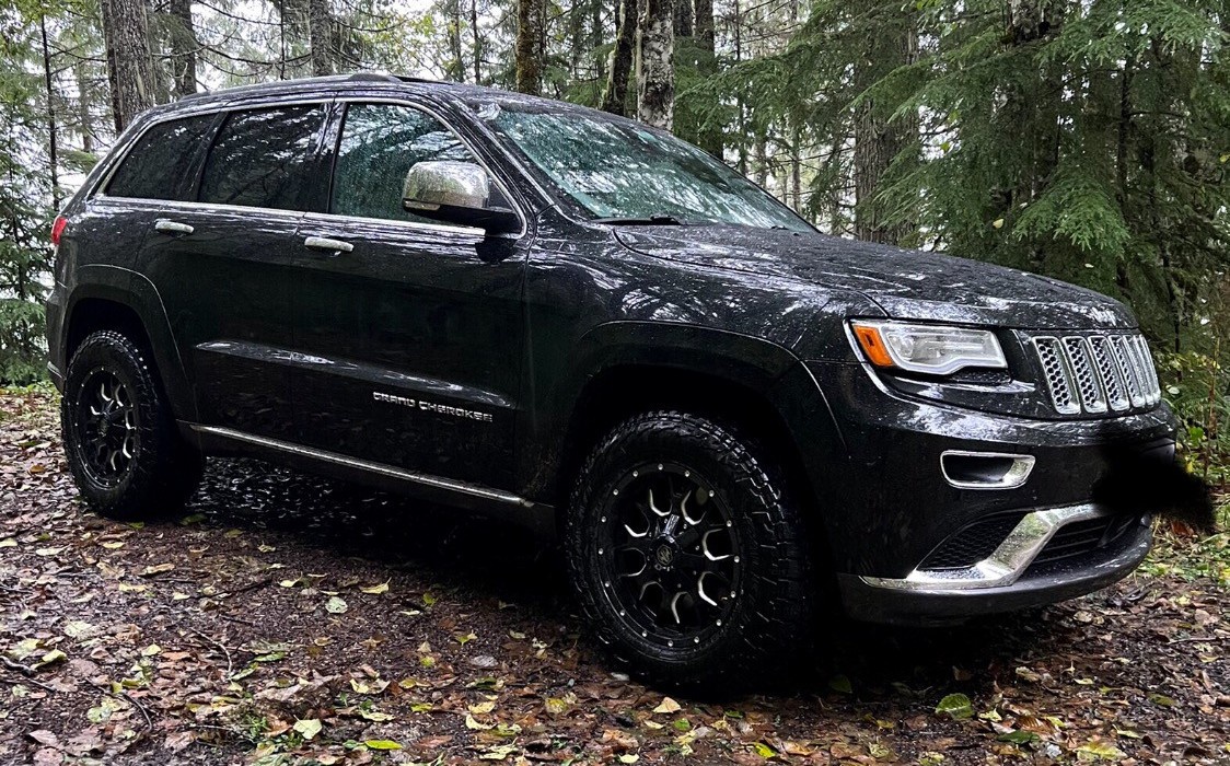 Profile view of black Jeep Grand Cherokee on trail