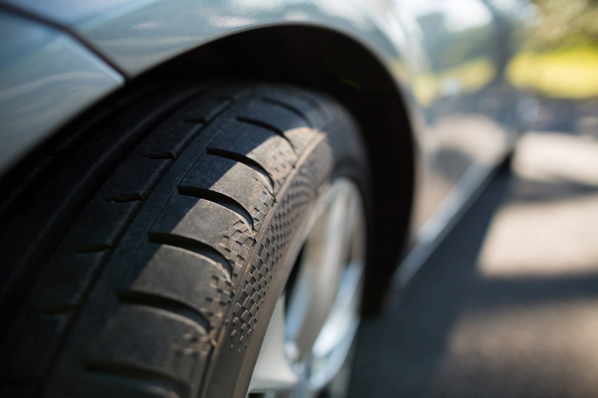 Isolated view of aftermarket tire on car