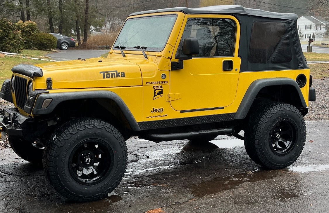 yellow jeep wrangler tj in parking lot