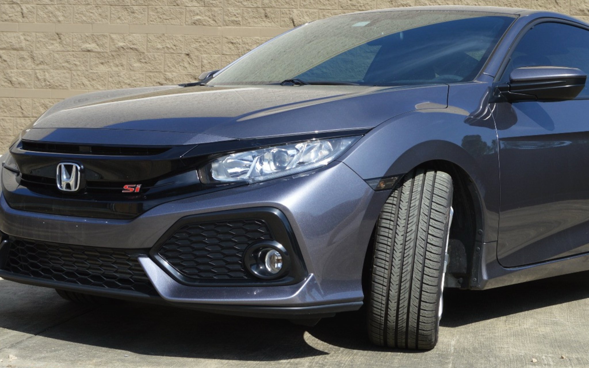 Honda Civic Si parked with the front tire turned outwards to show tread pattern