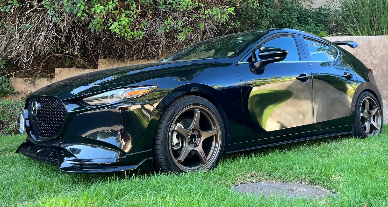 profile view of mazda sedan parked in grass