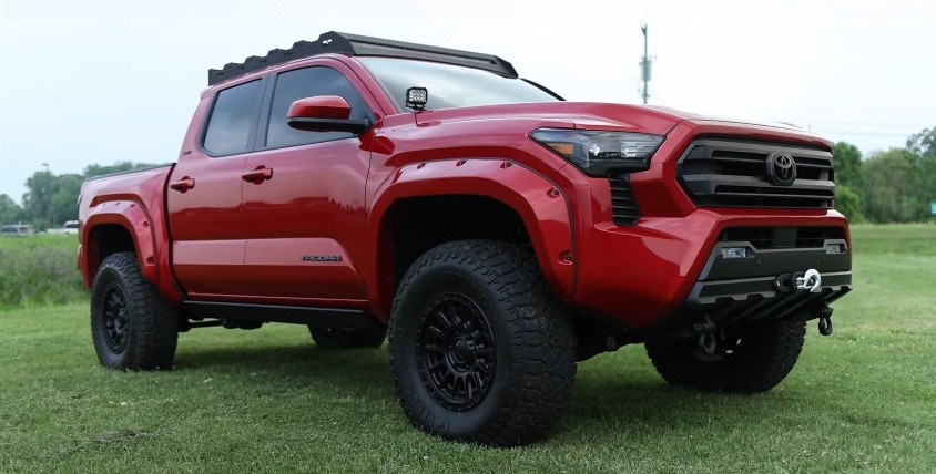 profile view of red toyota tacoma in yard
