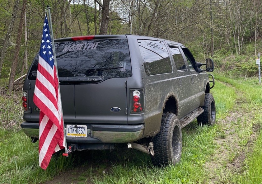 rear shot of black ford excursion on trail