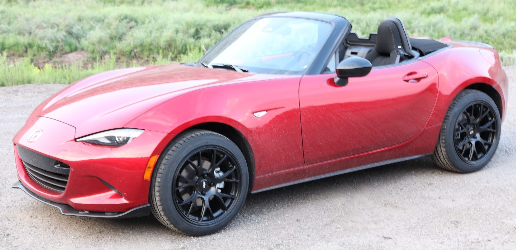 red miata on dirt road