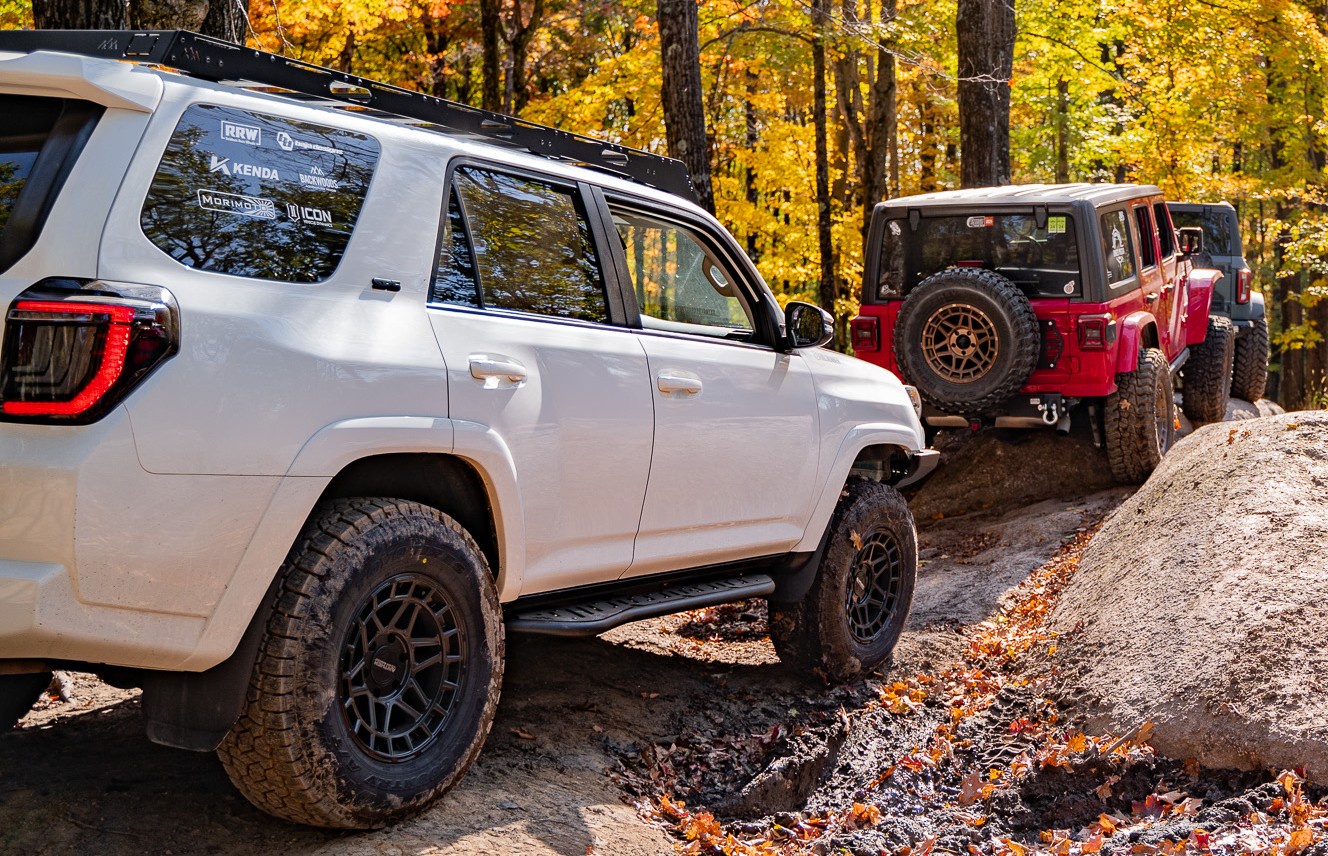 line of off-roaders driving on trail with anthem valor truck wheels trailbuilt offroad