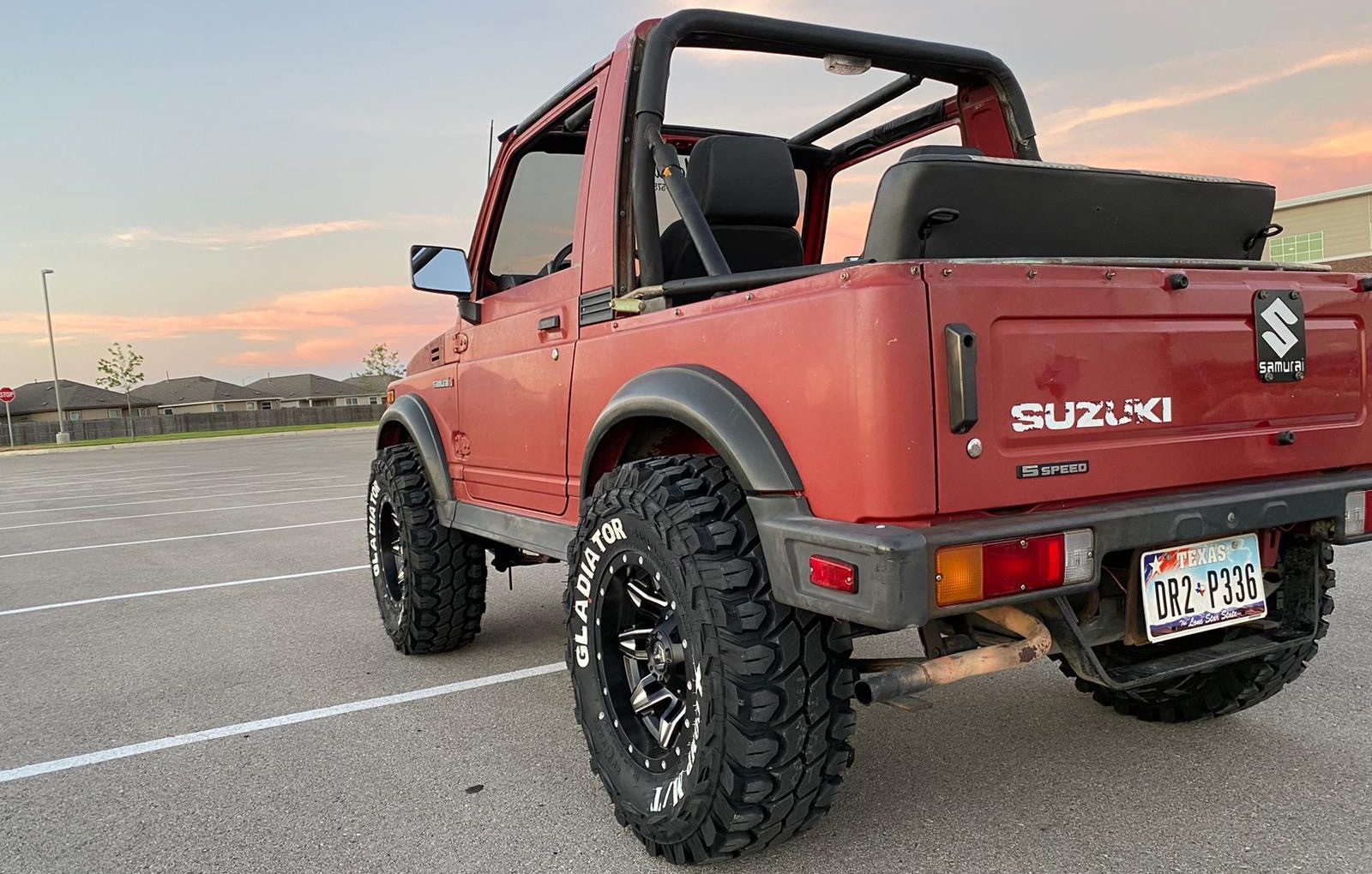 rear view of red suzuki samurai in driveway against sunset