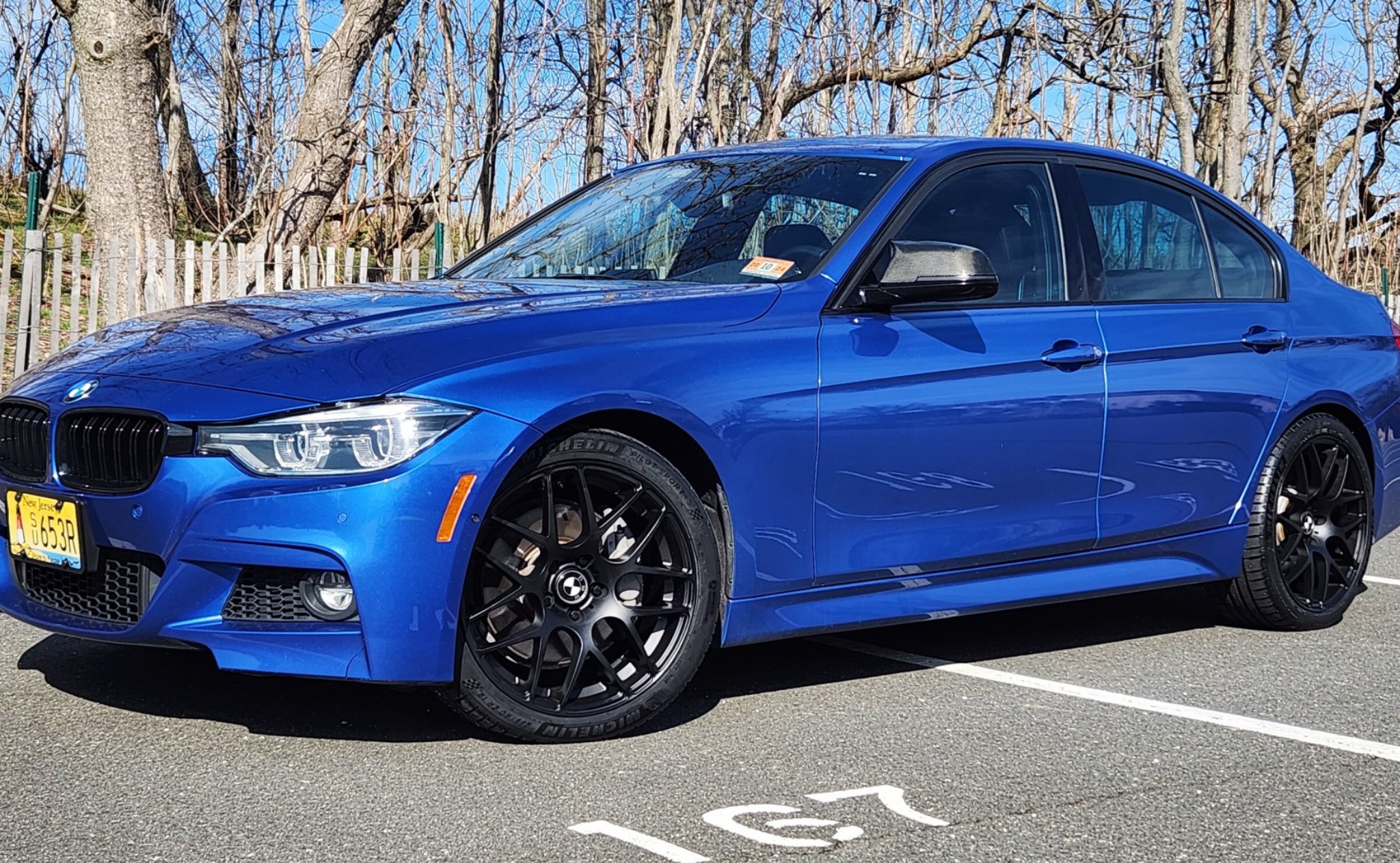 Blue BMW 3 Series sedan with black aftermarket wheels and run-flat tires