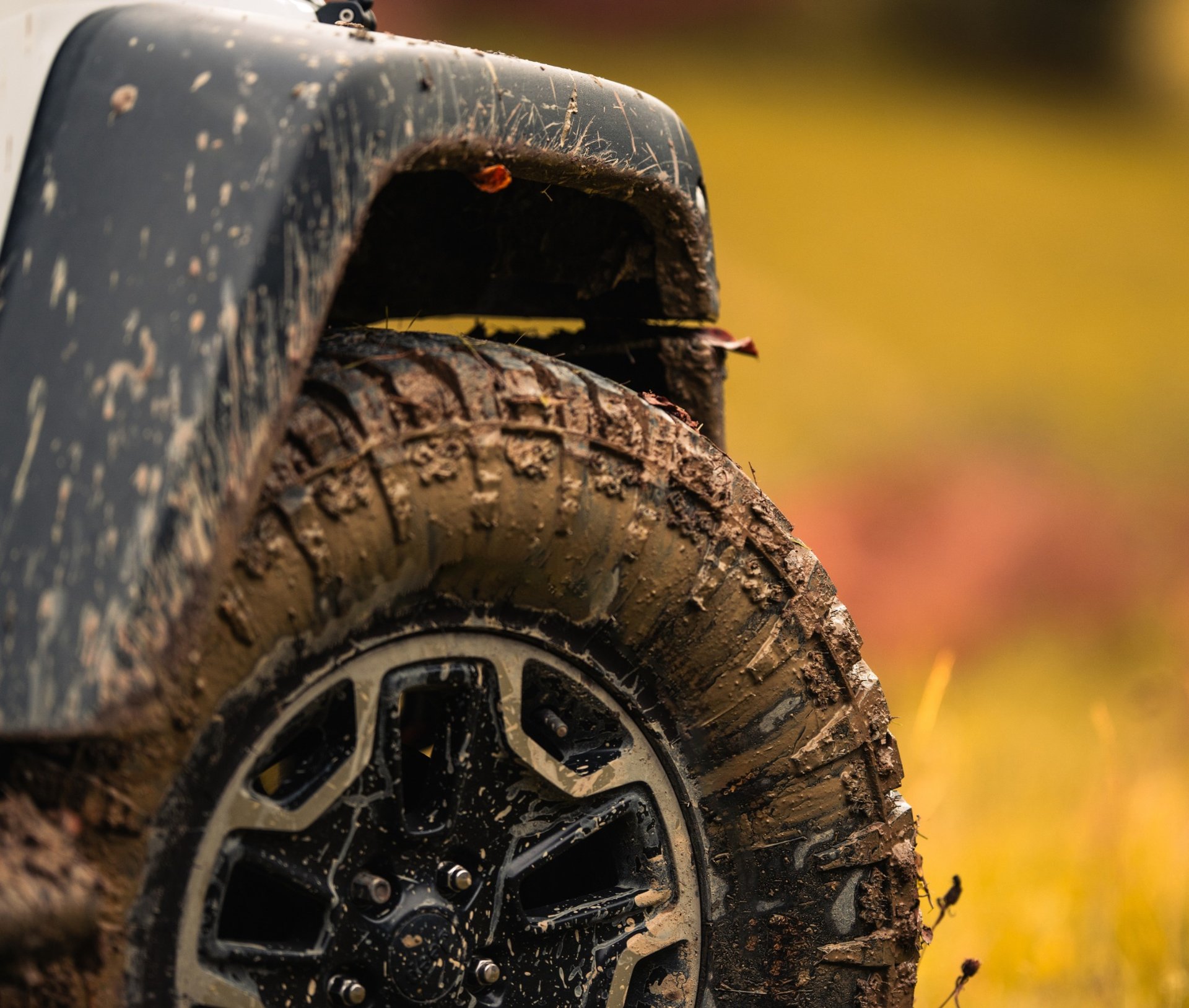 Mud covered wheel and tire of a Jeep Wrangler after off-road driving