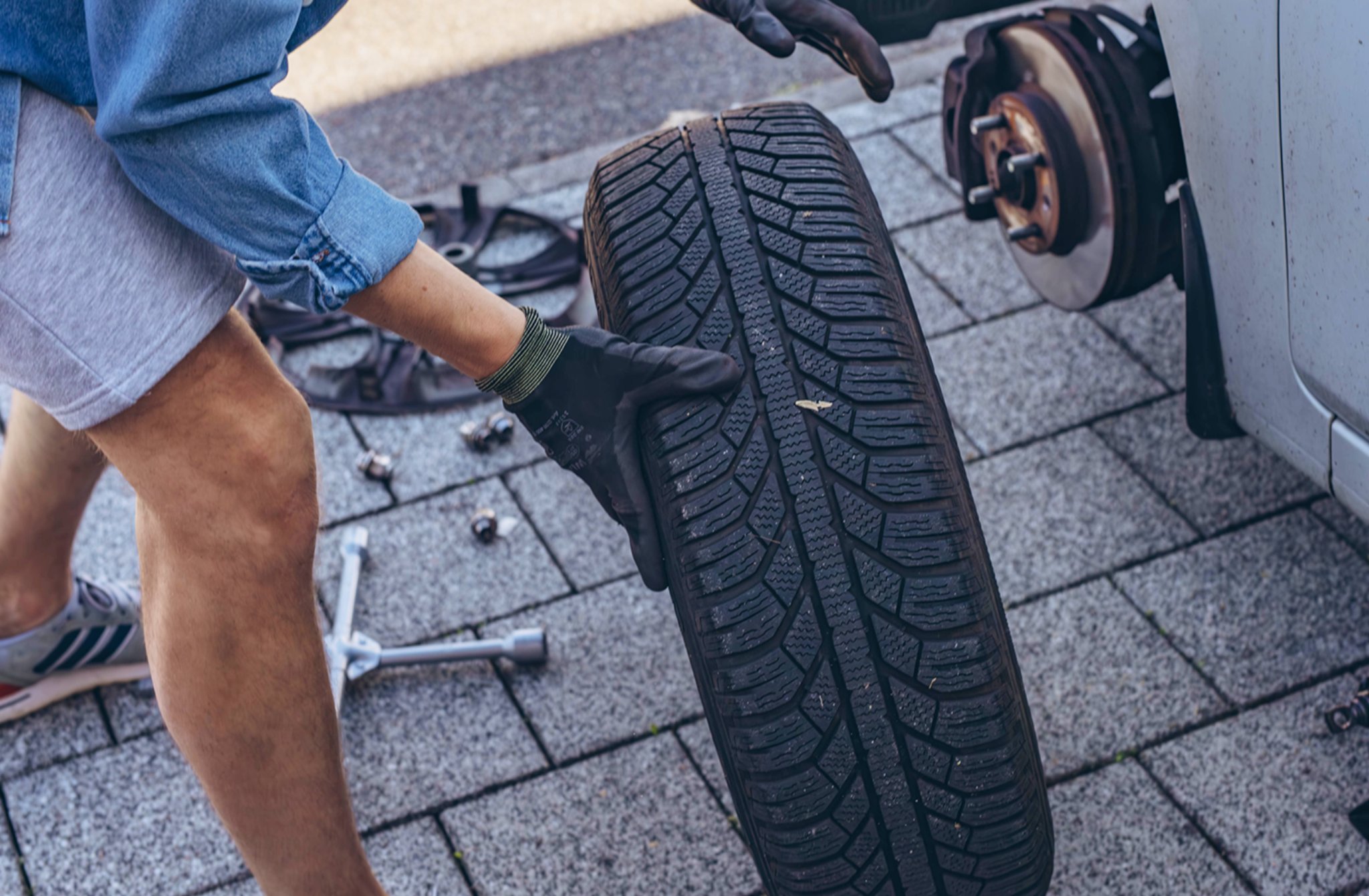 Person lifting a tire during a tire change