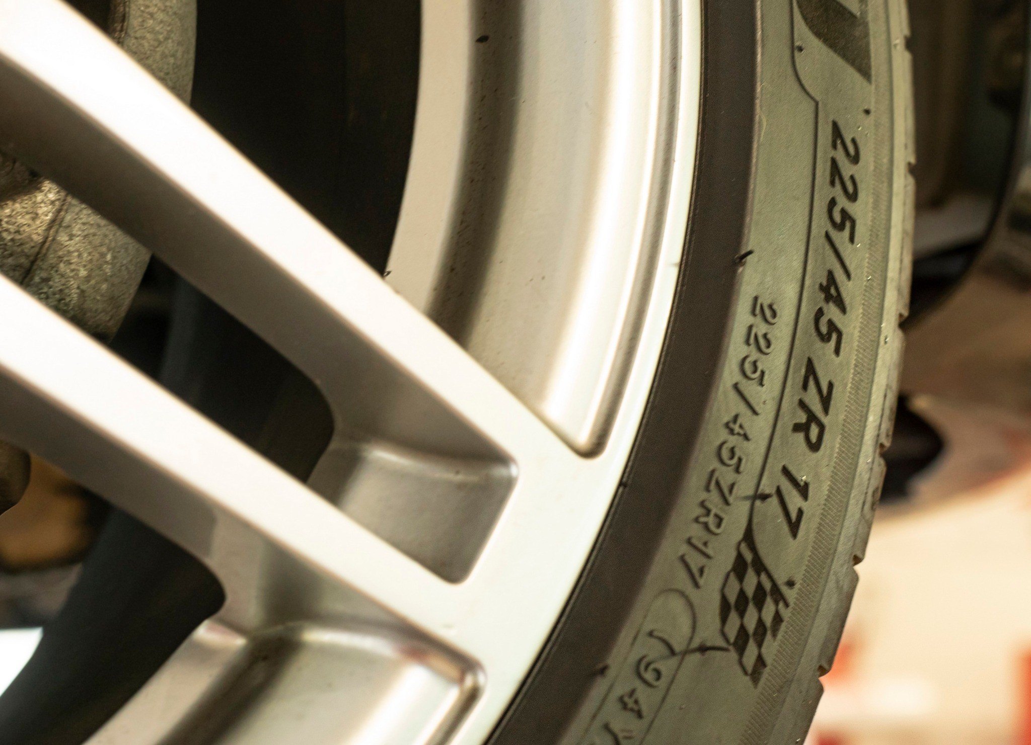 close up of tire size codes on a car with parts of the wheel visible