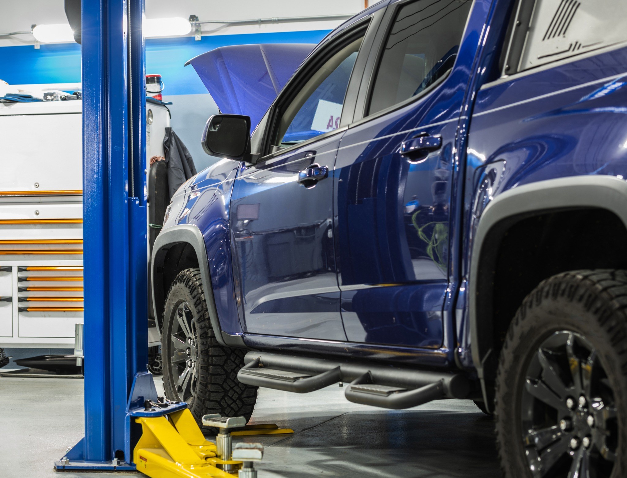 Blue Toyota Tacoma truck getting work down in a shop