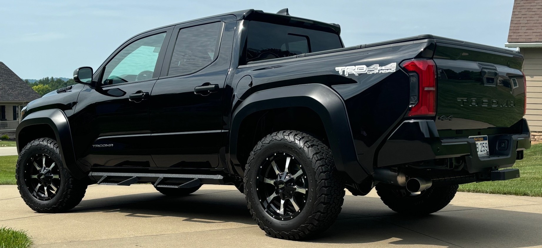 profile view of black toyota tacoma in driveway