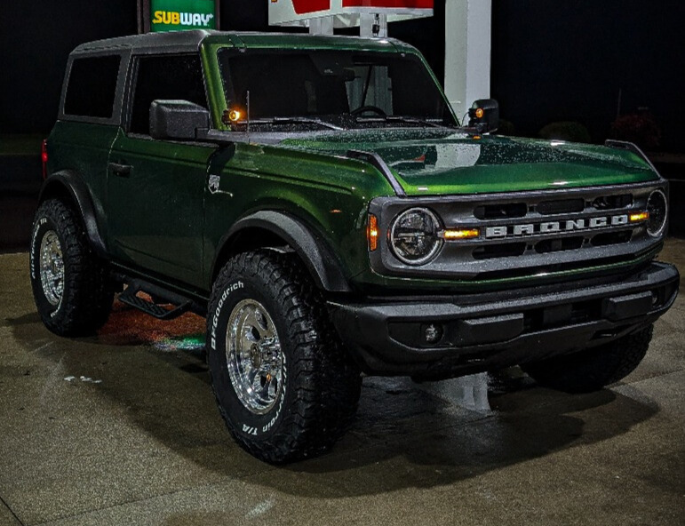green ford bronco in gas station lot