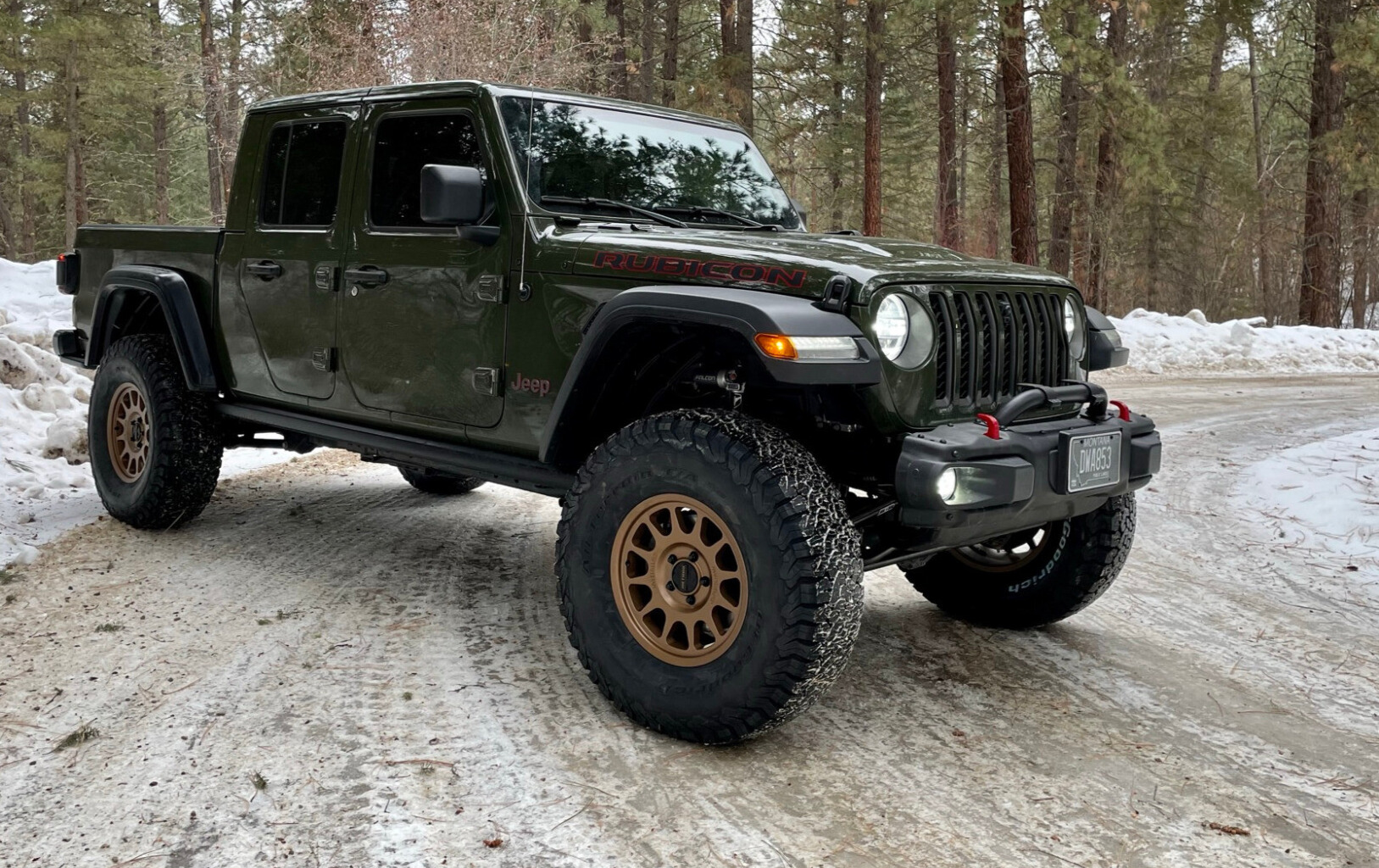 green jeep wrangler on snowy trail
