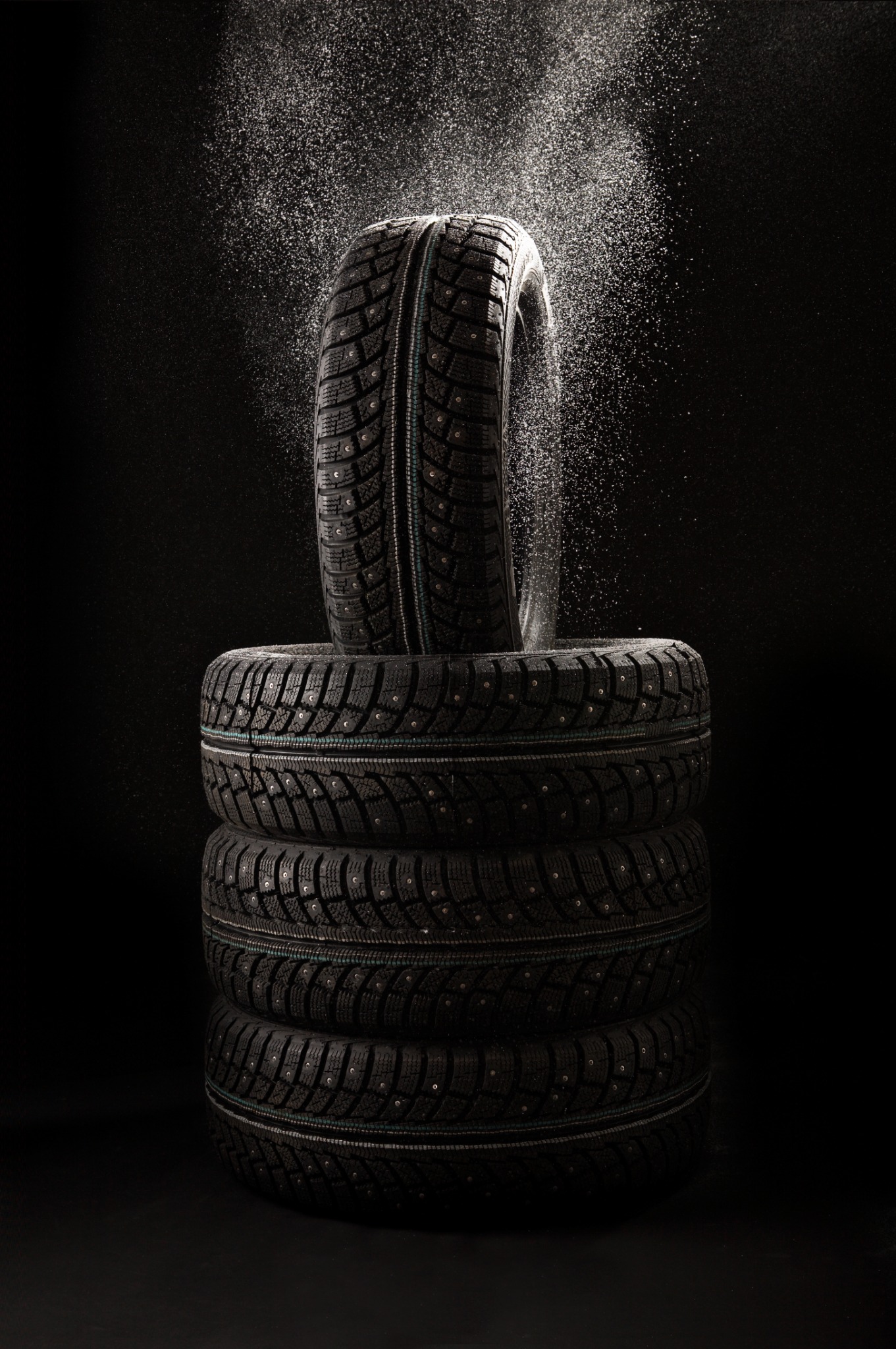 Stack of winter tires on black background