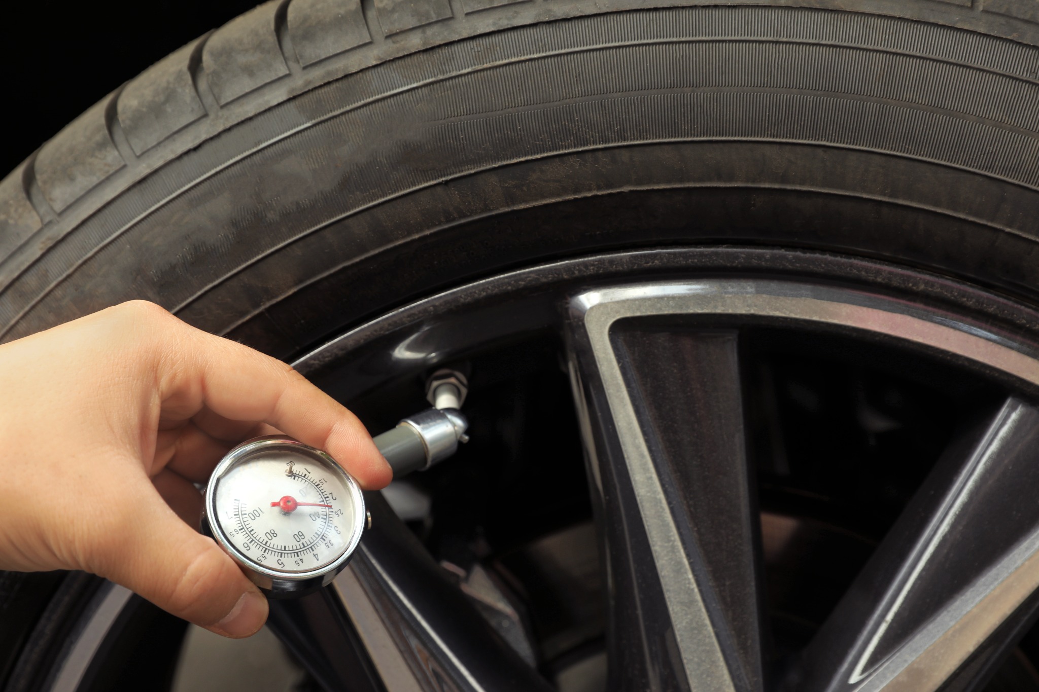 Manually checking tire pressure using gauge