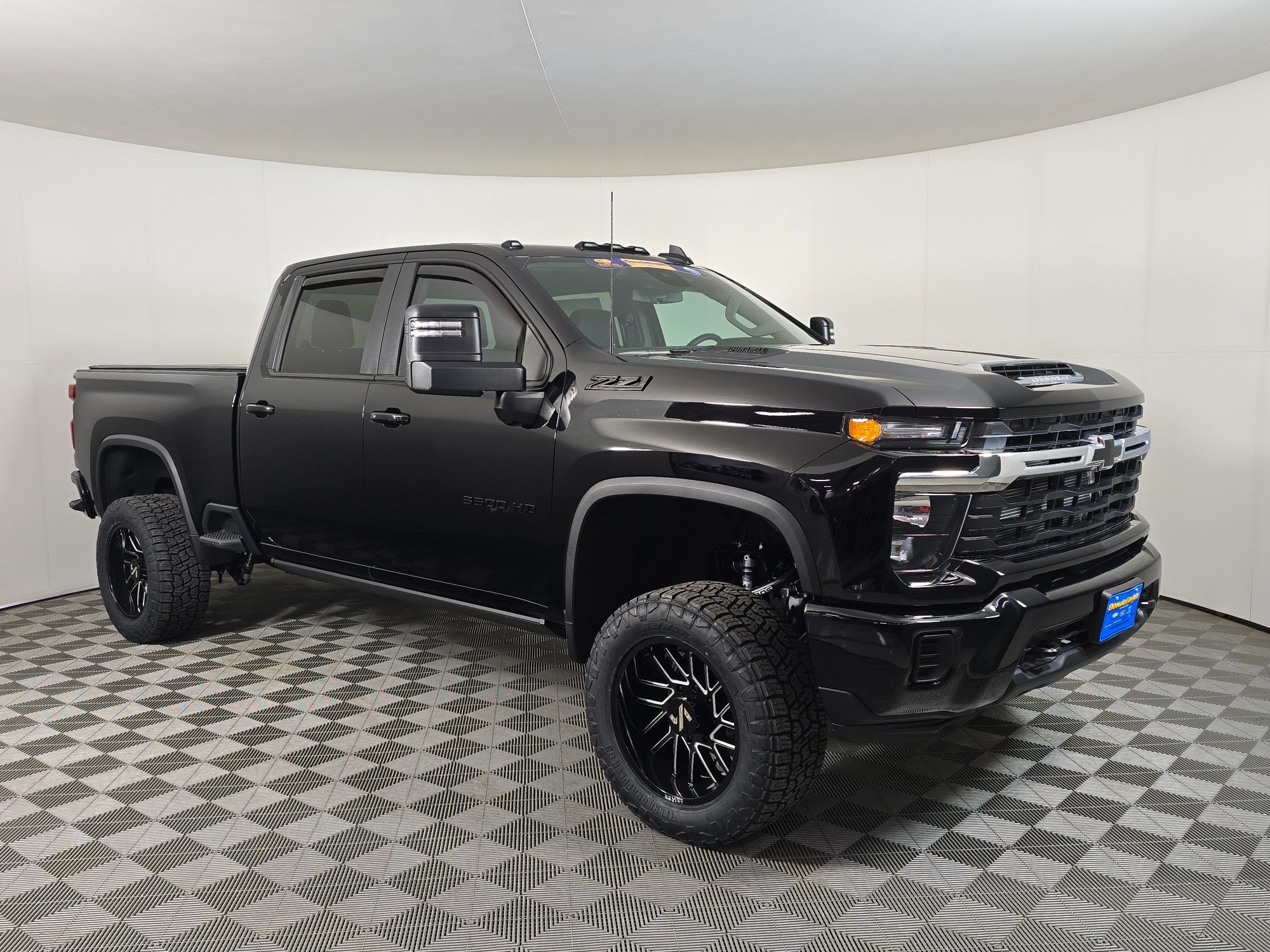 Lifted half ton, 3/4 ton, and one ton pickups lined up side by side, front three-quarter view