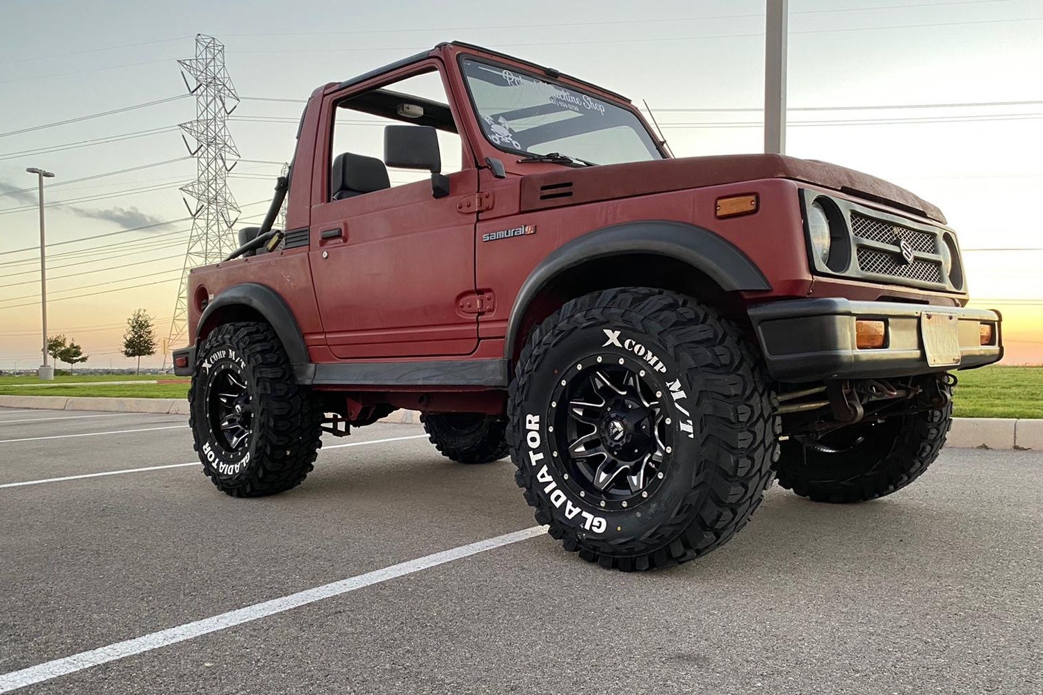 profile view of red suzuki samurai in parking lot