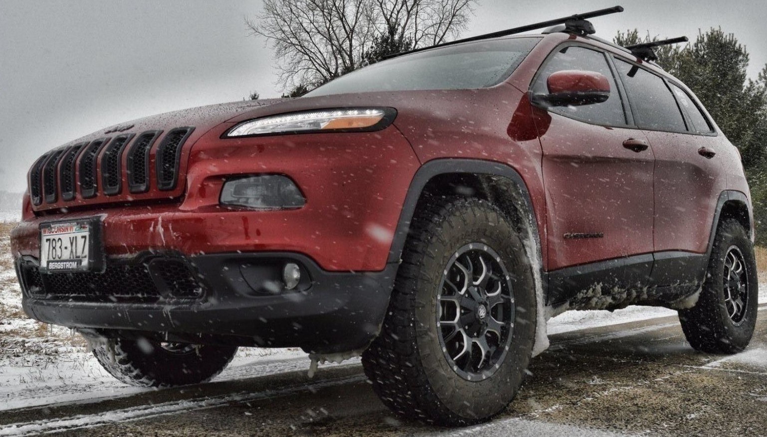 front view of red jeep cherokee on snowy road