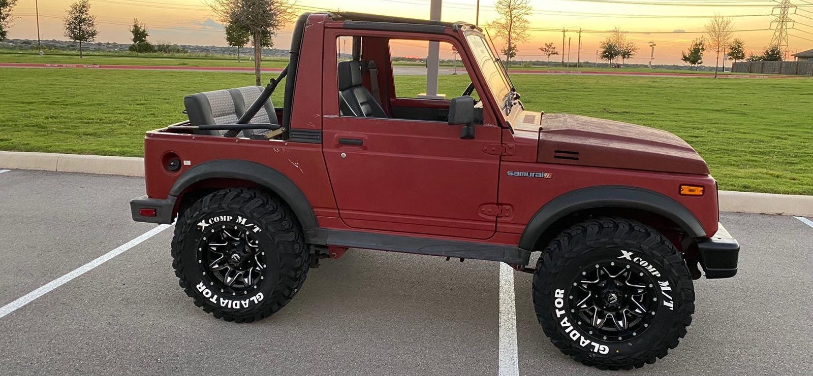 profile view of red suzuki samurai