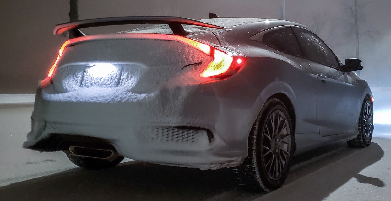 rear view of white honda driving in snow