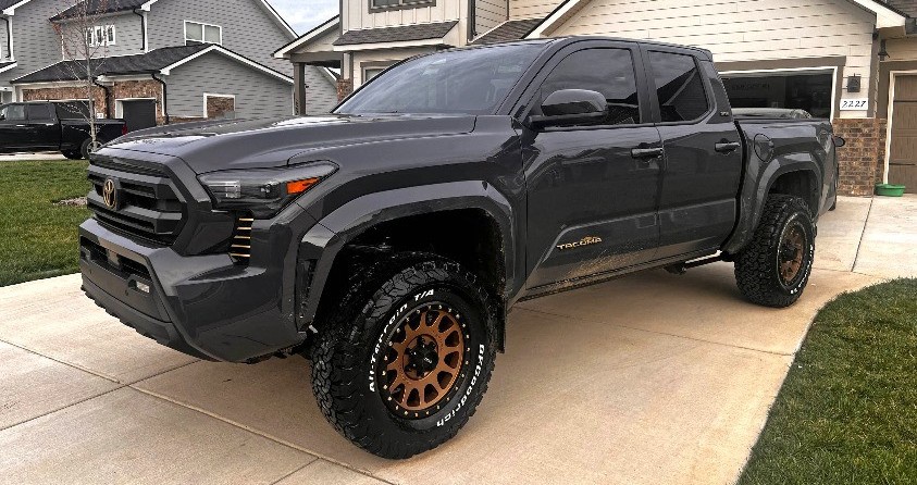 profile view of black toyota tacoma on driveway