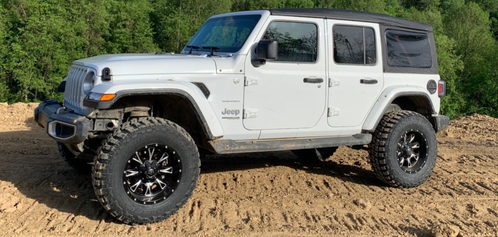 profile view of white jeep wrangler on trail
