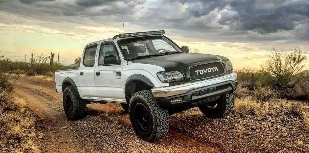front view of black and white toyota tacoma on trail
