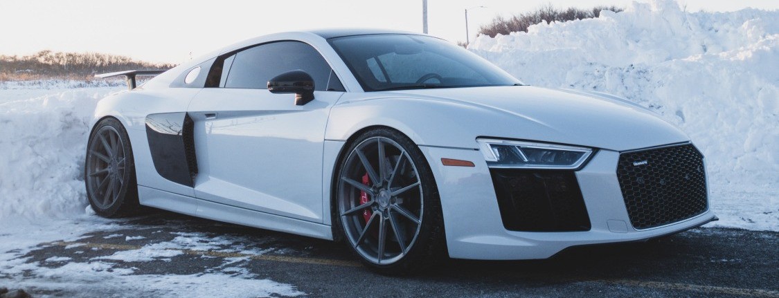 profile view of white audi in snowy parking lot