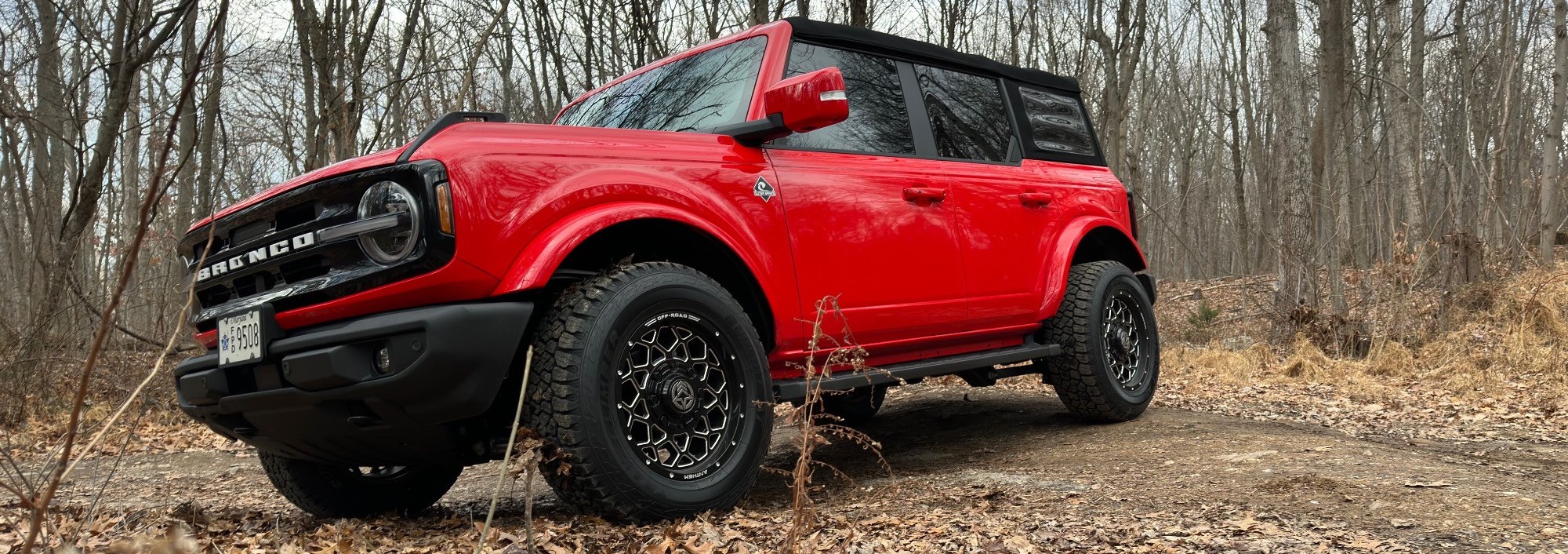 profile view of red ford bronco on trail